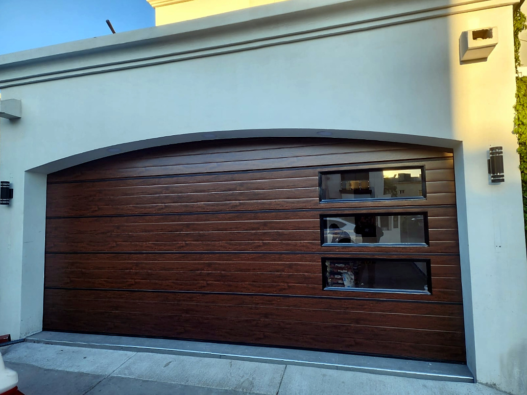 Puerta de cochera seccional en madera con ventanas