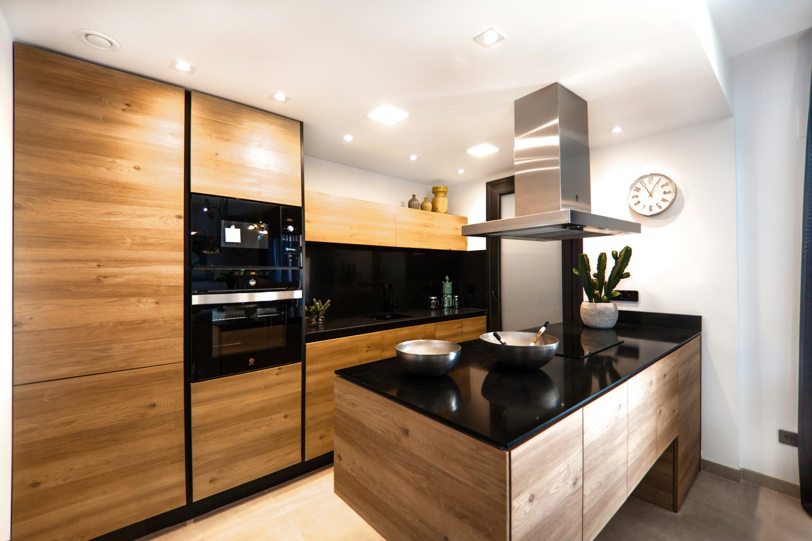 Cocina con gabinetes a techo en veta de madera y cubierta negra