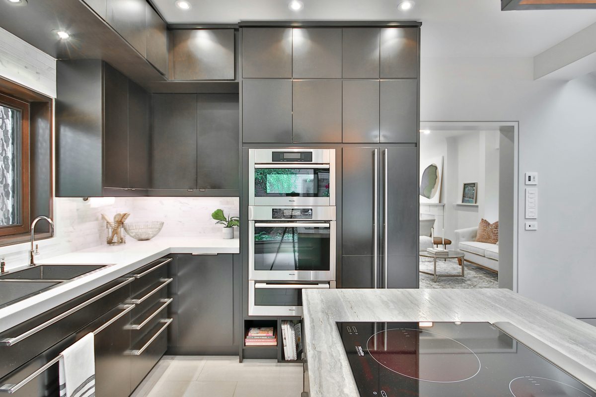 Cocina de gabinetes oscuros con metal